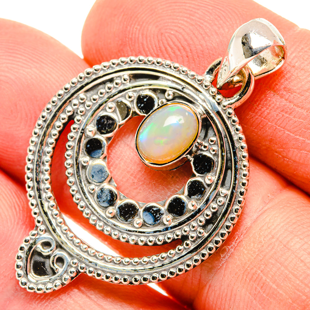 Sterling silver opal pendant close-up with blue gemstone ring and top loop bail