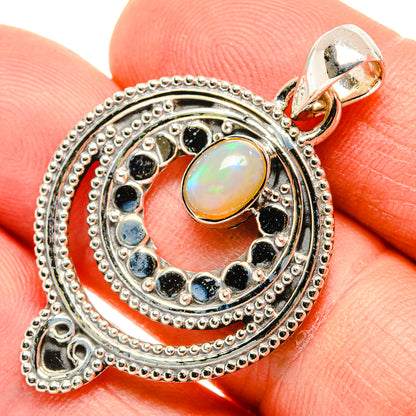 Sterling silver opal pendant close-up with blue gemstone ring and top loop bail