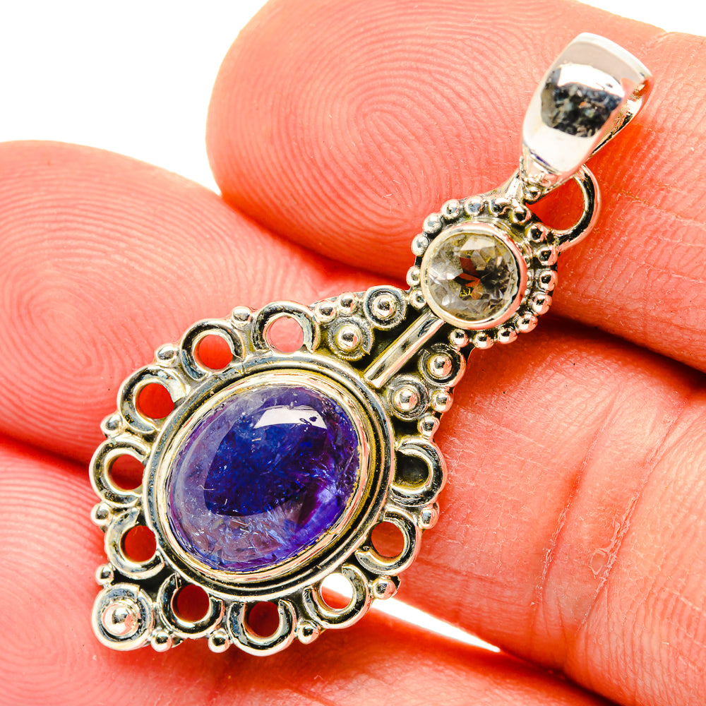 Sterling silver pendant close-up with oval blue gemstone, small yellow accents, hanging loop