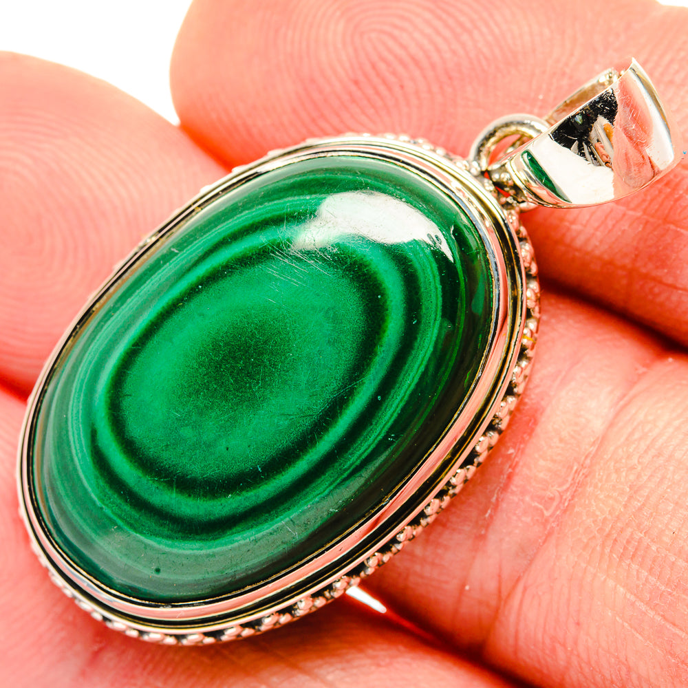 Oval malachite pendant with green swirls, 925 sterling silver frame and bail.