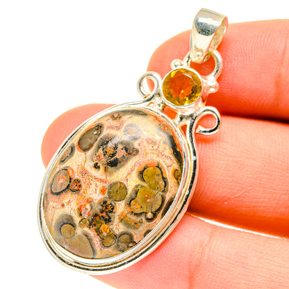 Sterling silver oval jasper pendant with round citrine gemstone, on fingertip