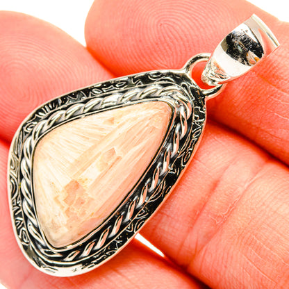 Ornate sterling silver scolecite pendant close-up with peach gemstone and curled rope frame