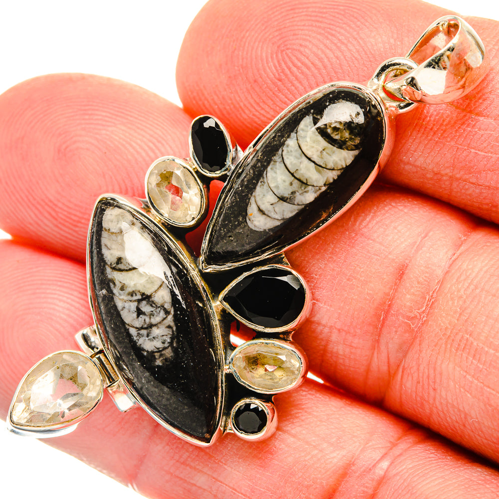 Black and white marbled pendant with heart and teardrop accents, bezel-set in gold-tone metal