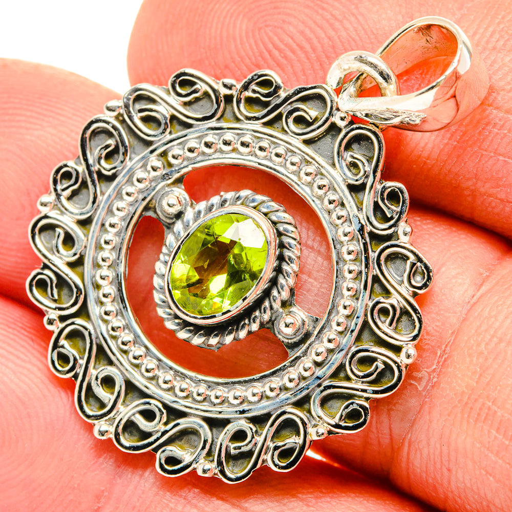 Sterling silver peridot pendant with round green stone in ornate oval frame