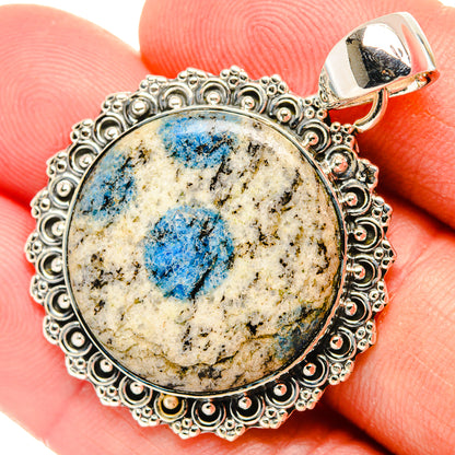 Oval sterling silver pendant with blue azurite cabochon in ornate scalloped bezel