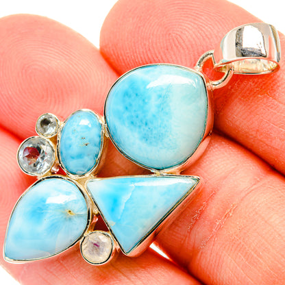 Blue stone pendant close-up, oval center and triangular drops with gold-tone bail