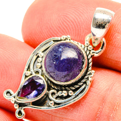 Sterling silver tanzanite pendant close-up with round blue-violet stone and oval side stone
