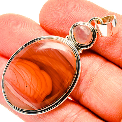 Sterling silver pendant with oval orange-red cabochon and small pink stone detail