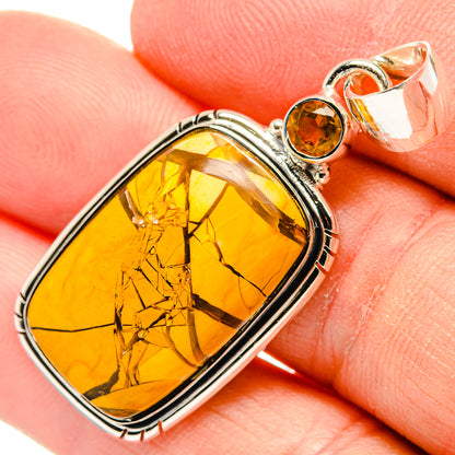 Close-up oval amber gemstone pendant with small round citrine bezel, silver