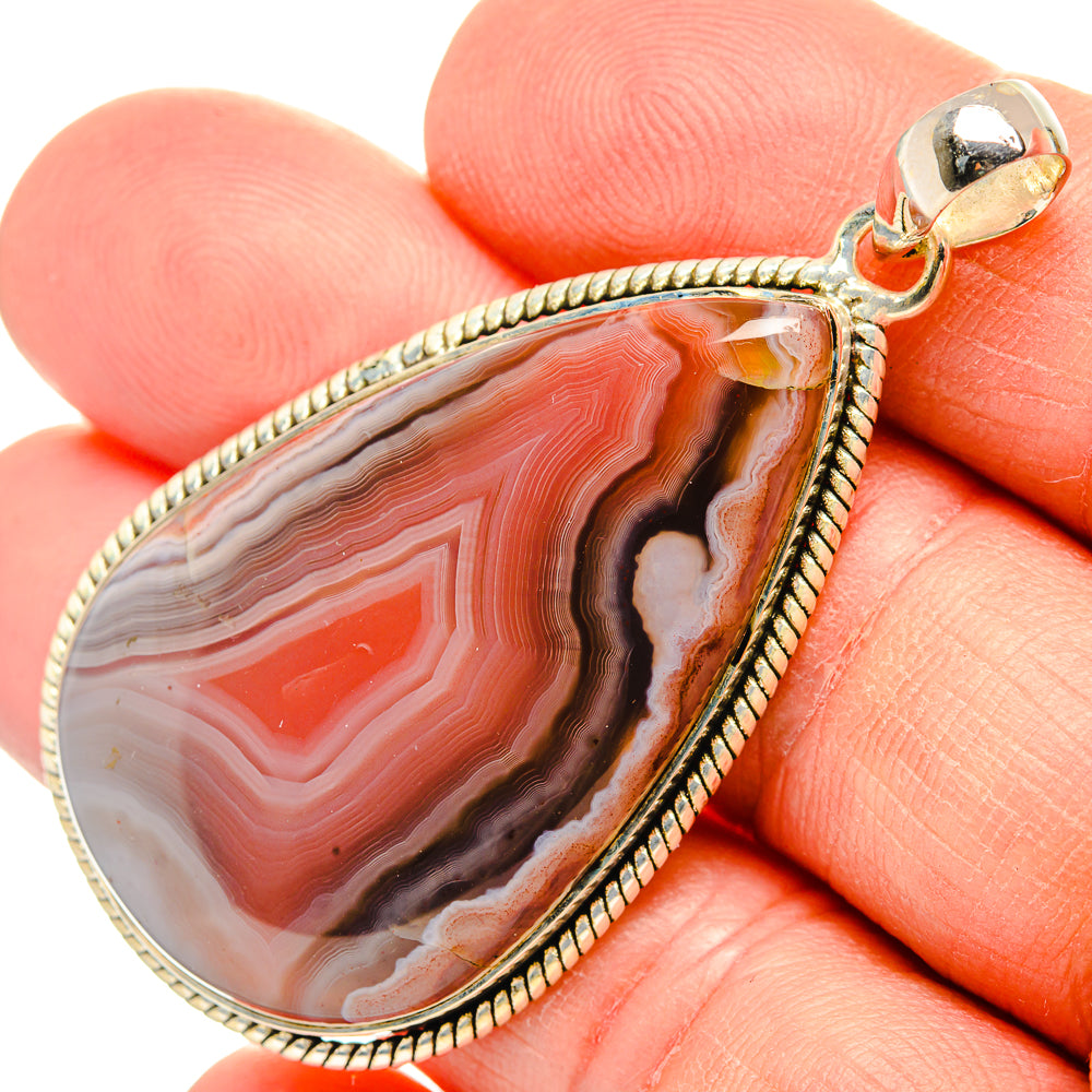 Close-up teardrop red agate pendant with 925 sterling silver bail and textured edge