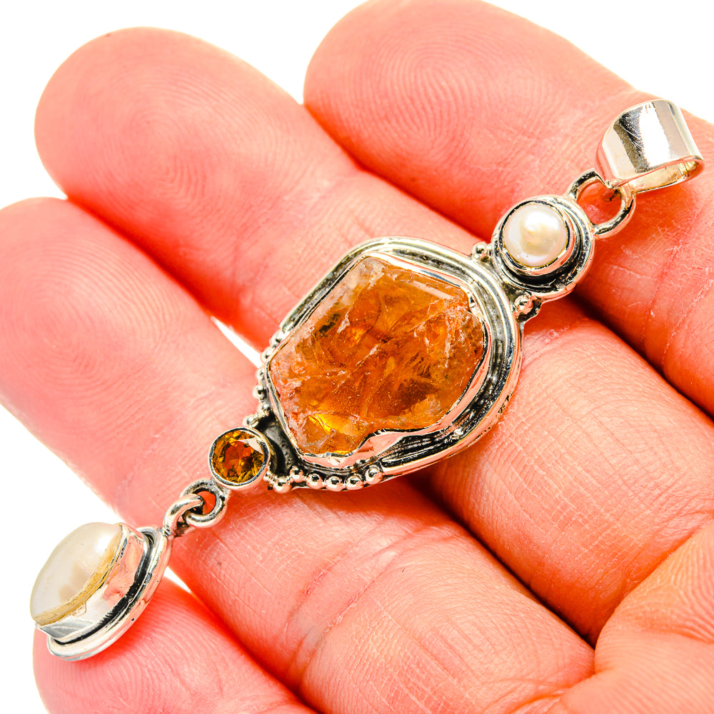Sterling silver pendant on chain with rough orange stone, pearls, and orange round accents