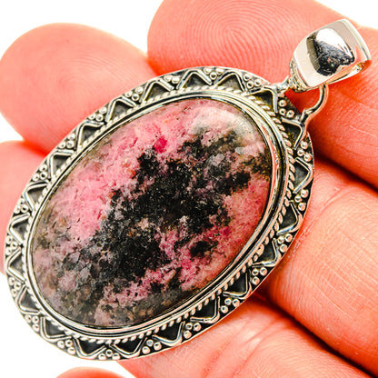 Oval rhodonite pendant with detailed 925 silver bezel and bail; close-up on stone