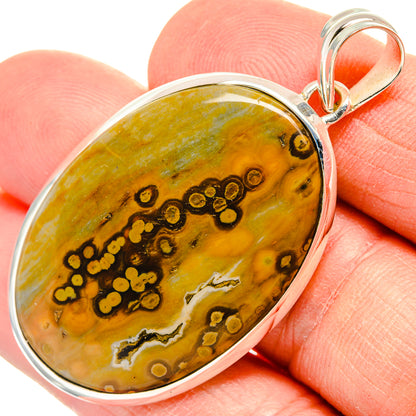 Ocean jasper oval pendant with sterling silver bezel and top bail, golden green stone.
