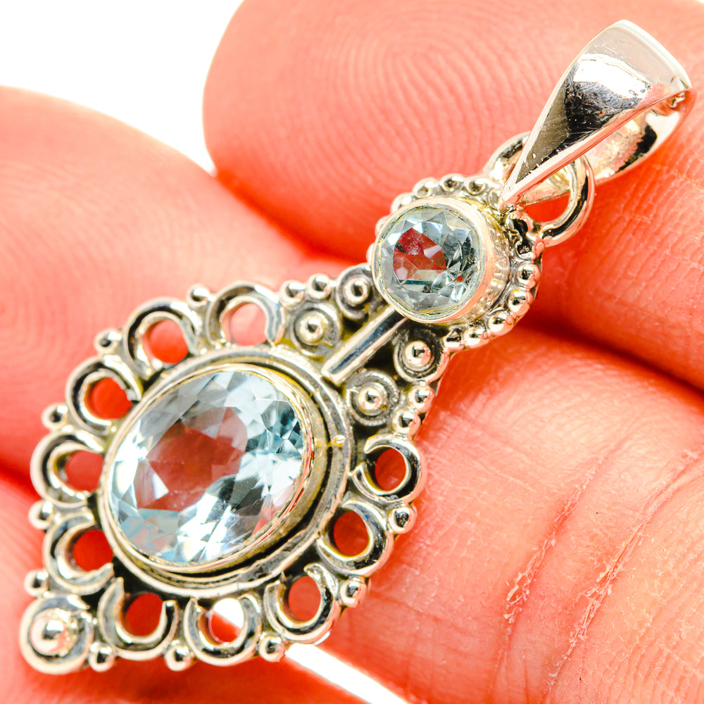 Blue topaz pendant detail with two round sky-blue stones and ornate silver filigree