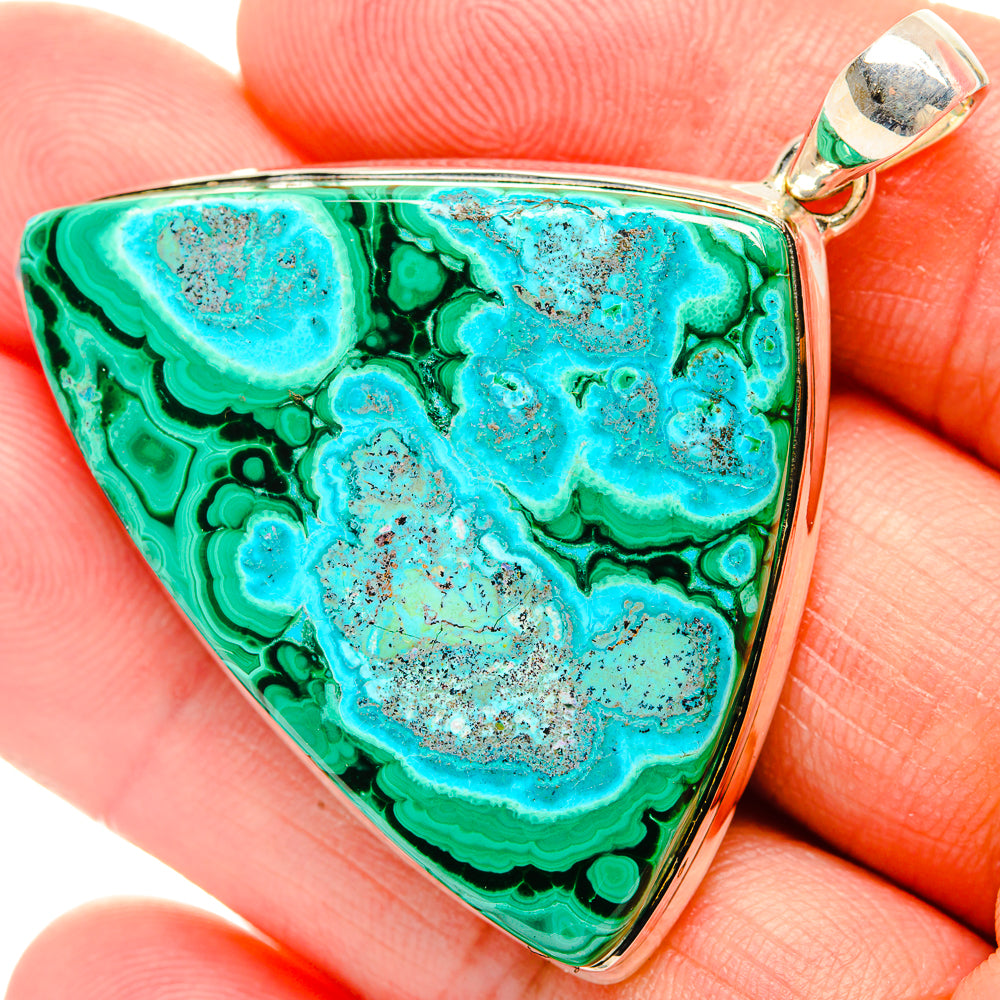 Triangular pendant close-up with green-blue stone texture and sterling silver bail
