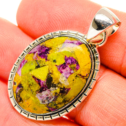 Oval sterling silver pendant with yellow and purple cabochon stone, bail at top