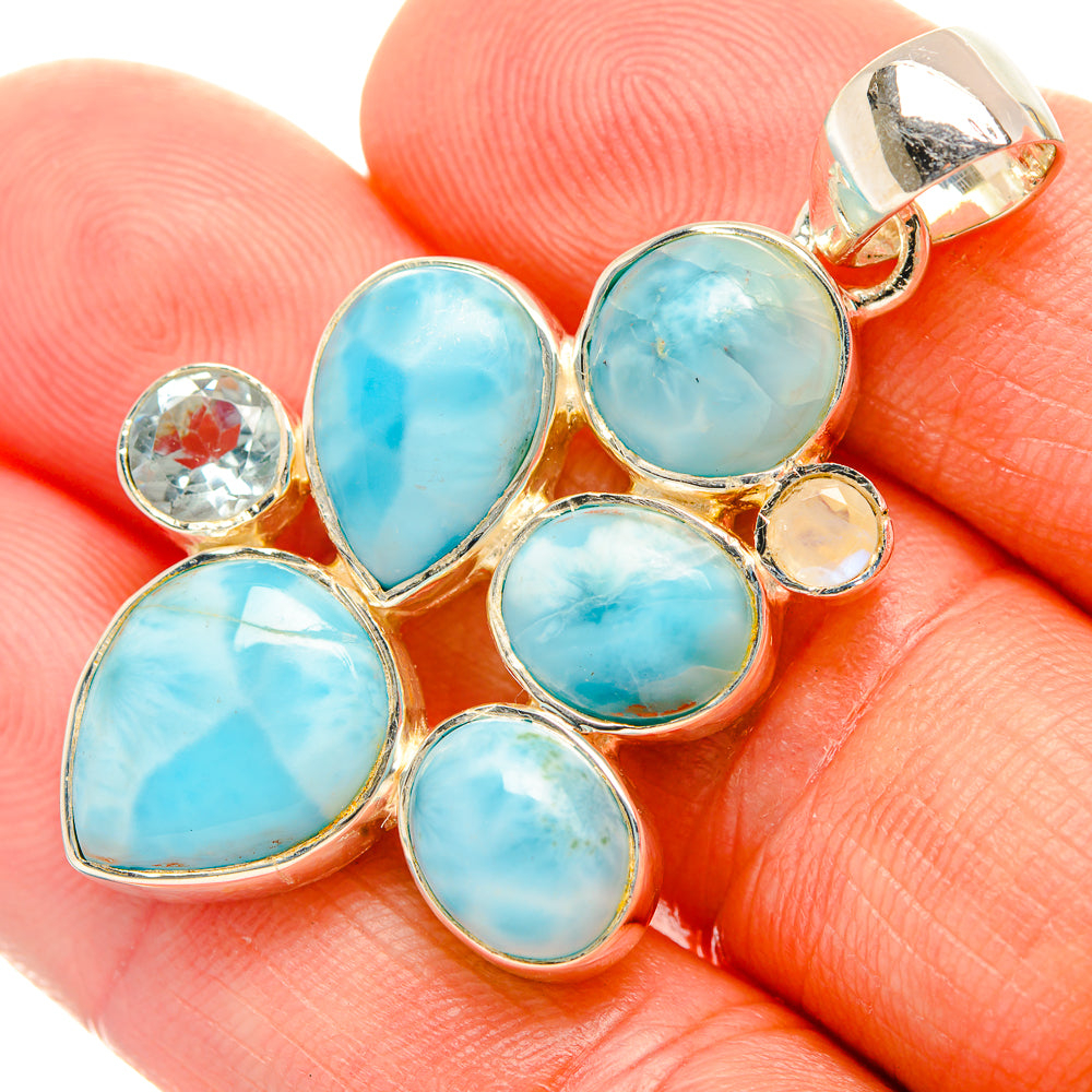 Gemstone pendant with blue teardrop and oval stones, round accents, gold-tone bezel and bail