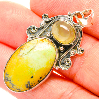 Sterling silver pendant with two oval yellow gemstones and ornate swirling bezel settings