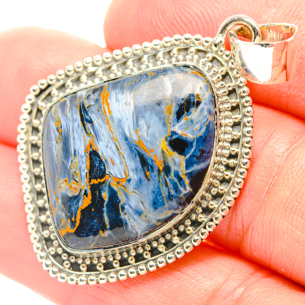 Close-up oval pietersite pendant with blue marbled stone in silver textured frame