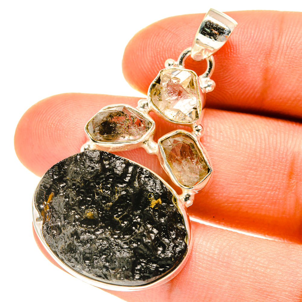 Sterling silver pendant with oval tektite stone and four bezel-set clear gems