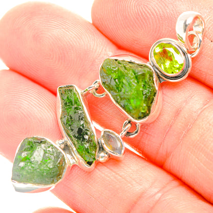 Silver-tone peridot pendant detail with rough green stones and oval bezel links