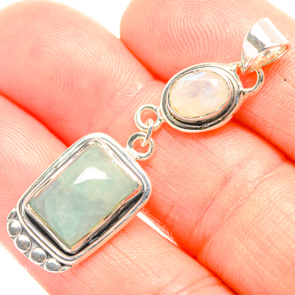Silver pendant close-up with rectangular aquamarine-toned stone and round opal cabochon