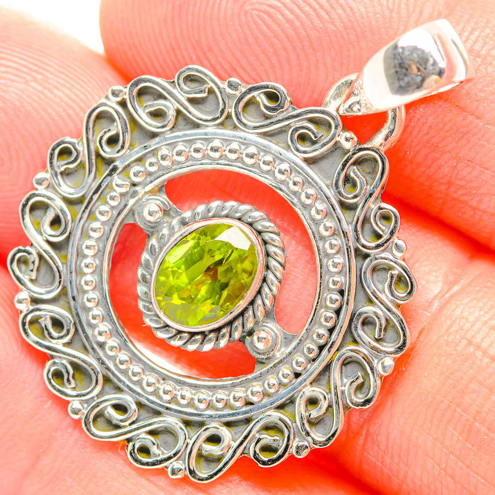 Peridot pendant with round green stone, ornate silver filigree and top bail