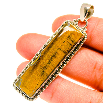 Rectangular tiger eye pendant close-up in silver bezel with textured edges and bail