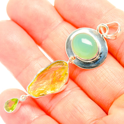 Sterling silver pendant on hand, featuring green oval cabochon and rough yellow drop