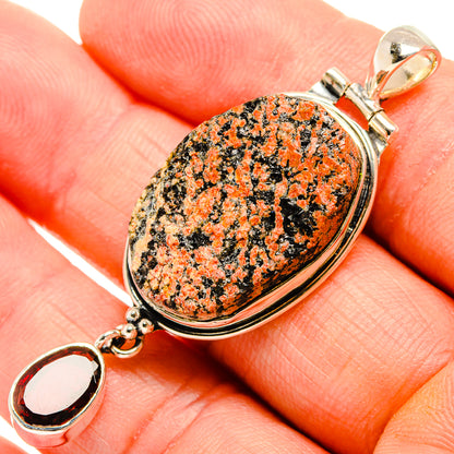 Oval orange-and-black stone pendant with 925 sterling silver bail and charm