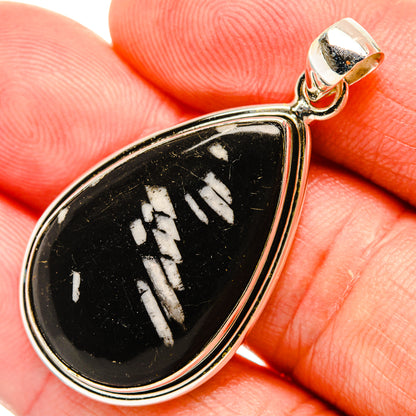 Sterling silver teardrop pendant with black stone and white carved pattern close-up