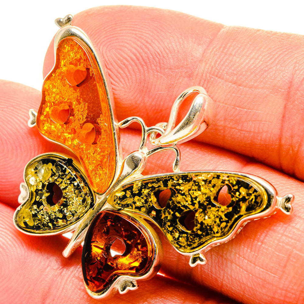 Amber butterfly pendant with red, yellow, and green tones and 925 sterling silver details