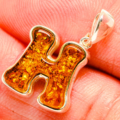 Amber letter H pendant in 925 sterling silver with a carved frame, yellow-orange amber.