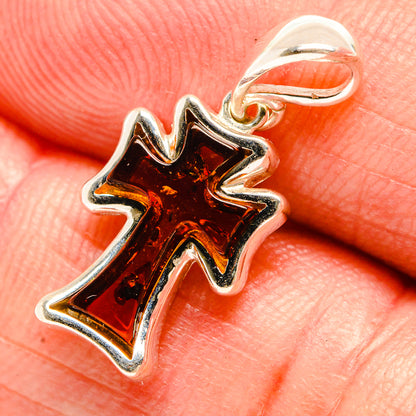 Sterling silver cross pendant with faceted red amber center and bail loop