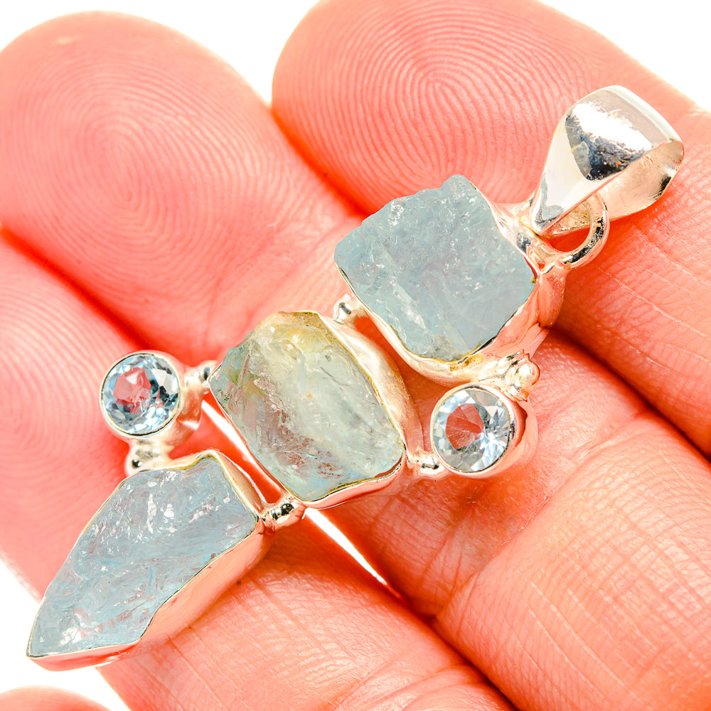 Close-up rough aquamarine-style pendant with blue topaz-like round stones, silver
