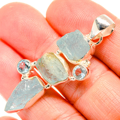 Close-up rough aquamarine-style pendant with blue topaz-like round stones, silver