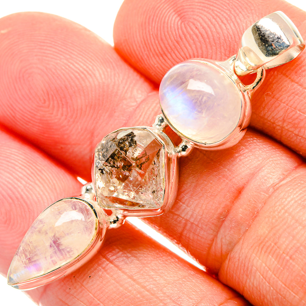 Sterling silver prong-set pendant close-up with moonstone cabochons and clear crystal stone