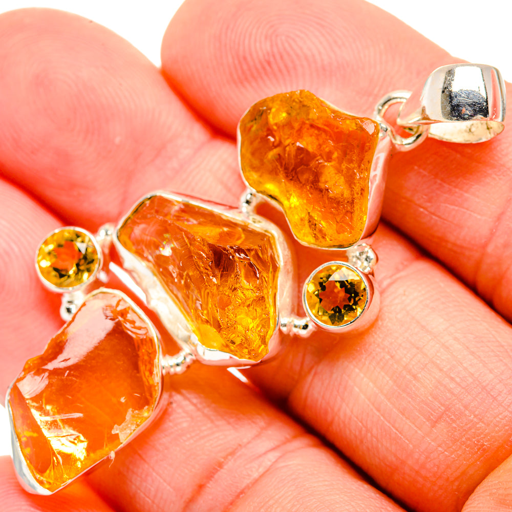 Rough citrine pendant close-up: silver frame with yellow-orange stone and round accents