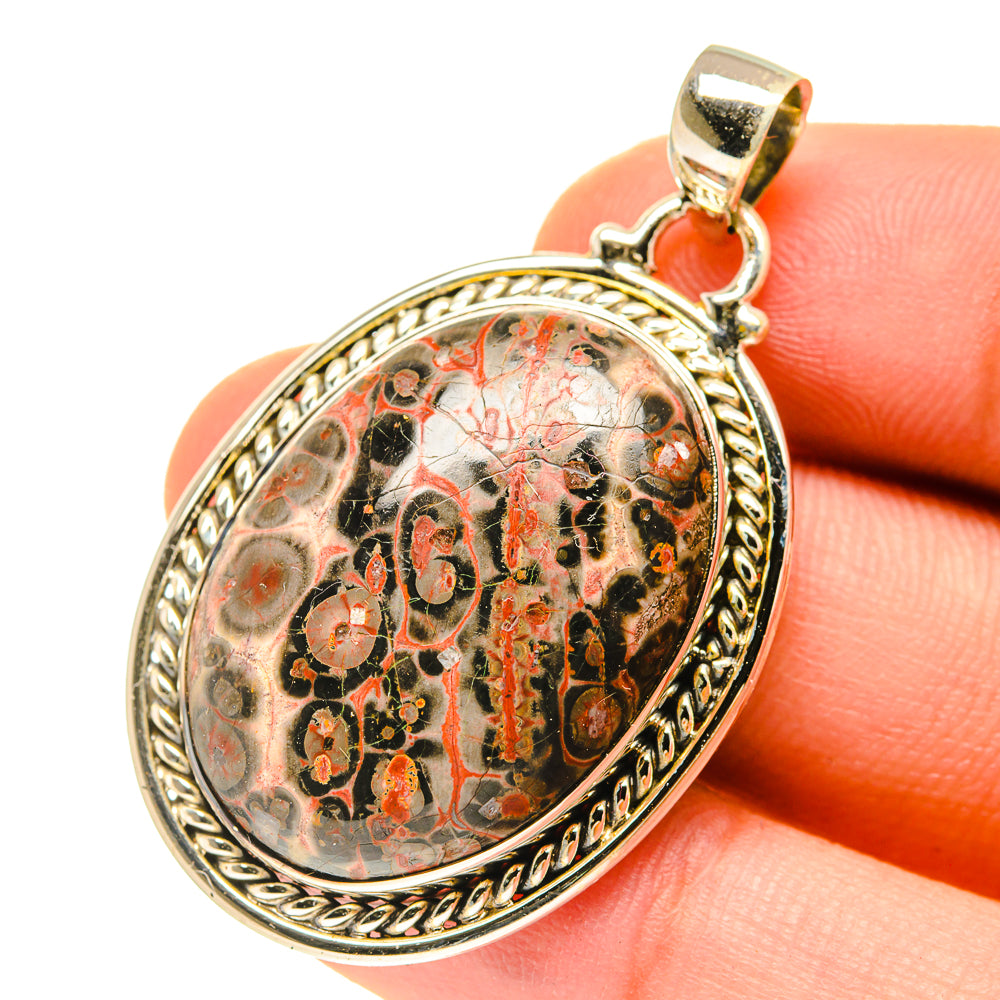 Oval jasper cabochon pendant on bail, ornate gold-tone bezel with red-and-black stone