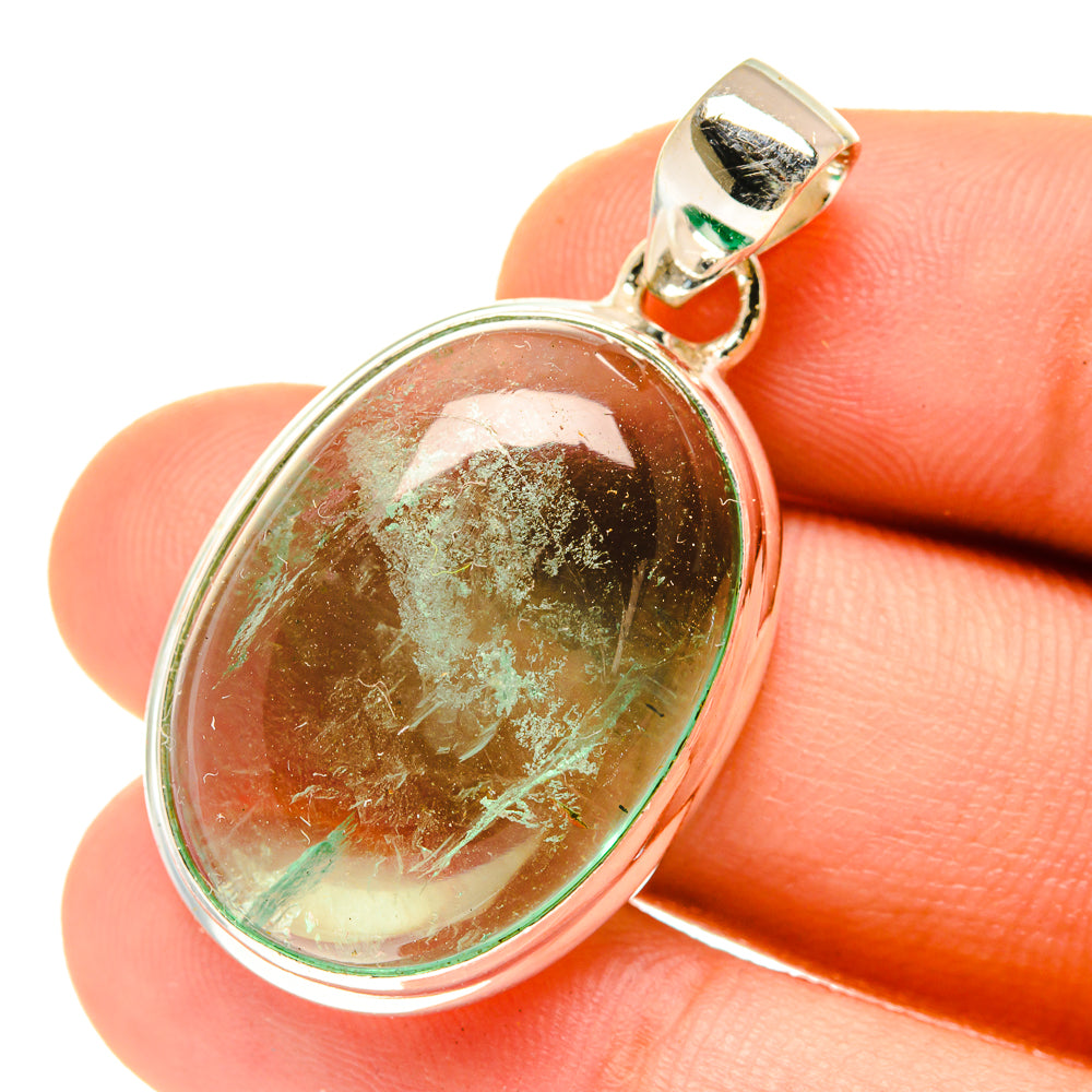 Green fluorite oval pendant in silver bezel, close-up on stone texture