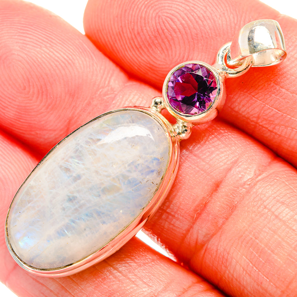 Oval rainbow moonstone pendant with round amethyst top and silver bail, close-up