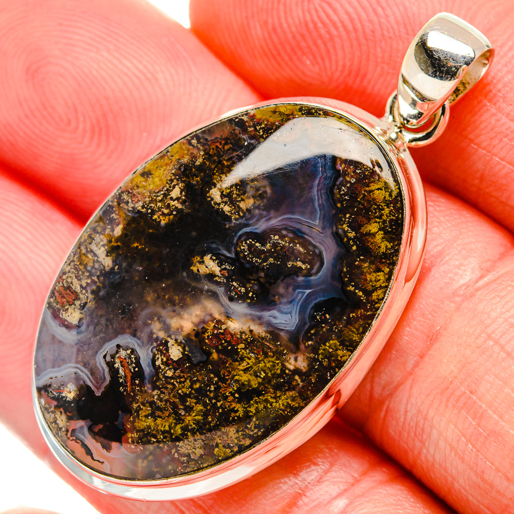 Oval plume agate pendant close-up with sterling silver bail; blue, amber, speckled inclusions