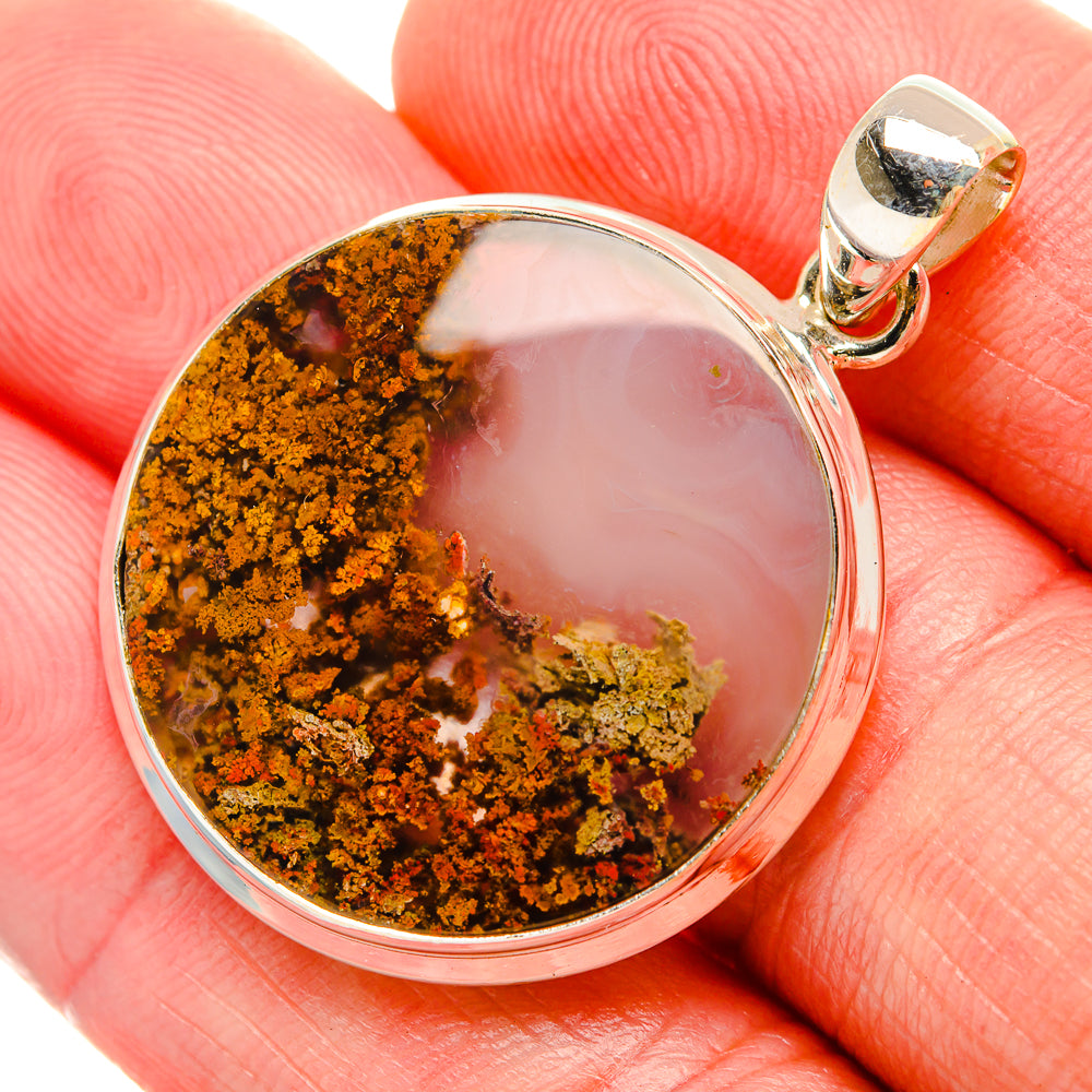 Round sterling silver plume agate pendant with orange-brown and white stone, bail at top