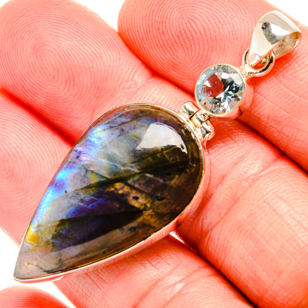 Teardrop labradorite pendant with blue topaz accents, gold-toned bezel on bail