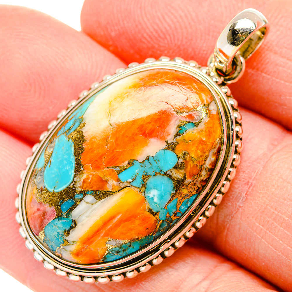Oval turquoise and orange stone pendant with beaded silver frame and gold-tone bail