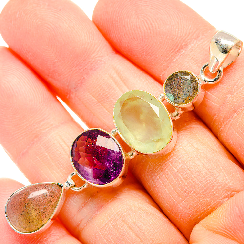 Sterling silver pendant with oval cabochons in green and purple, close-up on chain loop