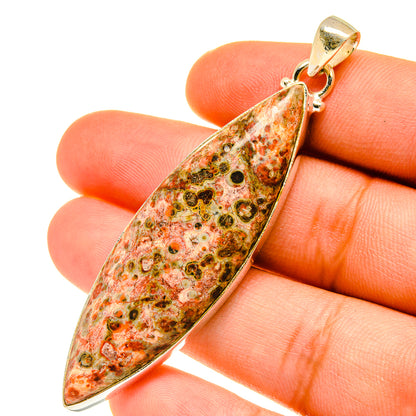 Teardrop poppy jasper pendant on fingertip, gold-toned bail and loop