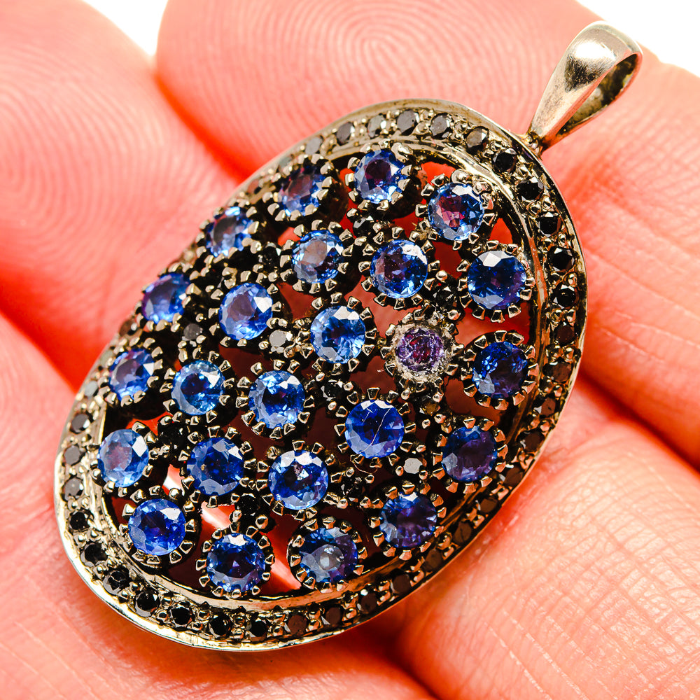 Oval tanzanite pendant close-up, faceted blue stones in 925 silver with black bezel