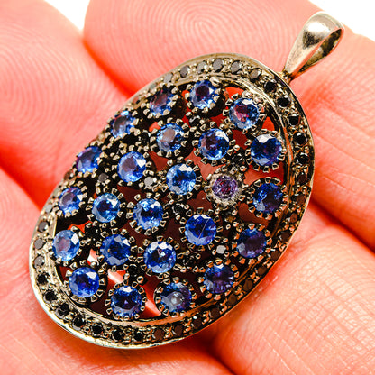 Oval tanzanite pendant close-up, faceted blue stones in 925 silver with black bezel