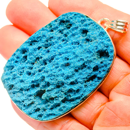 Large blue druzy pendant on gold-tone bail with faceted black speckled texture
